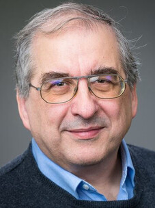 Joachim Wosnitza mit Brille und grauem Haar, freundlich vor neutralem Hintergrund.